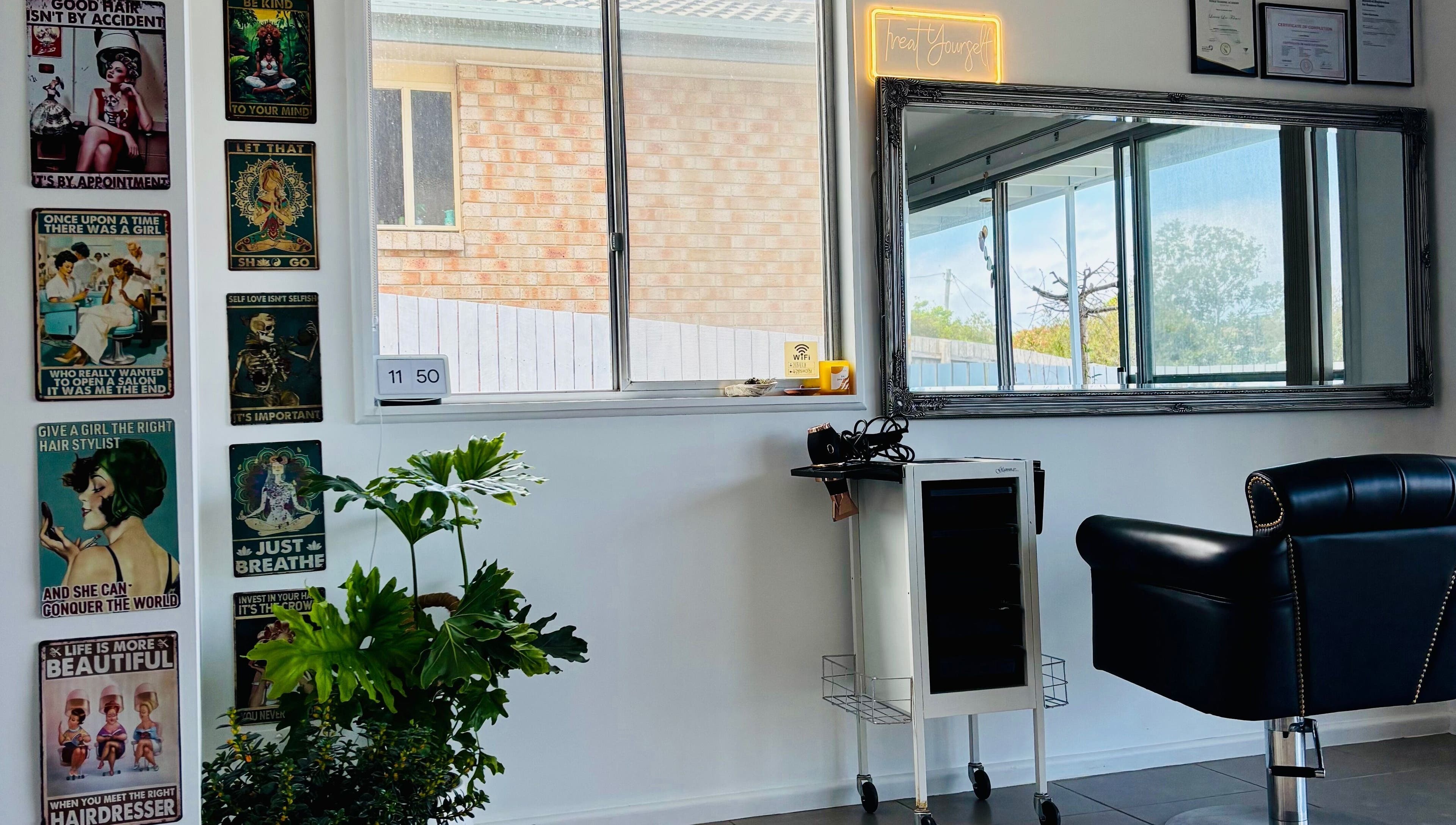 Chic salon interior with vintage posters and a styling chair at Tathra Hair Studio, Tathra, New South Wales, AU.