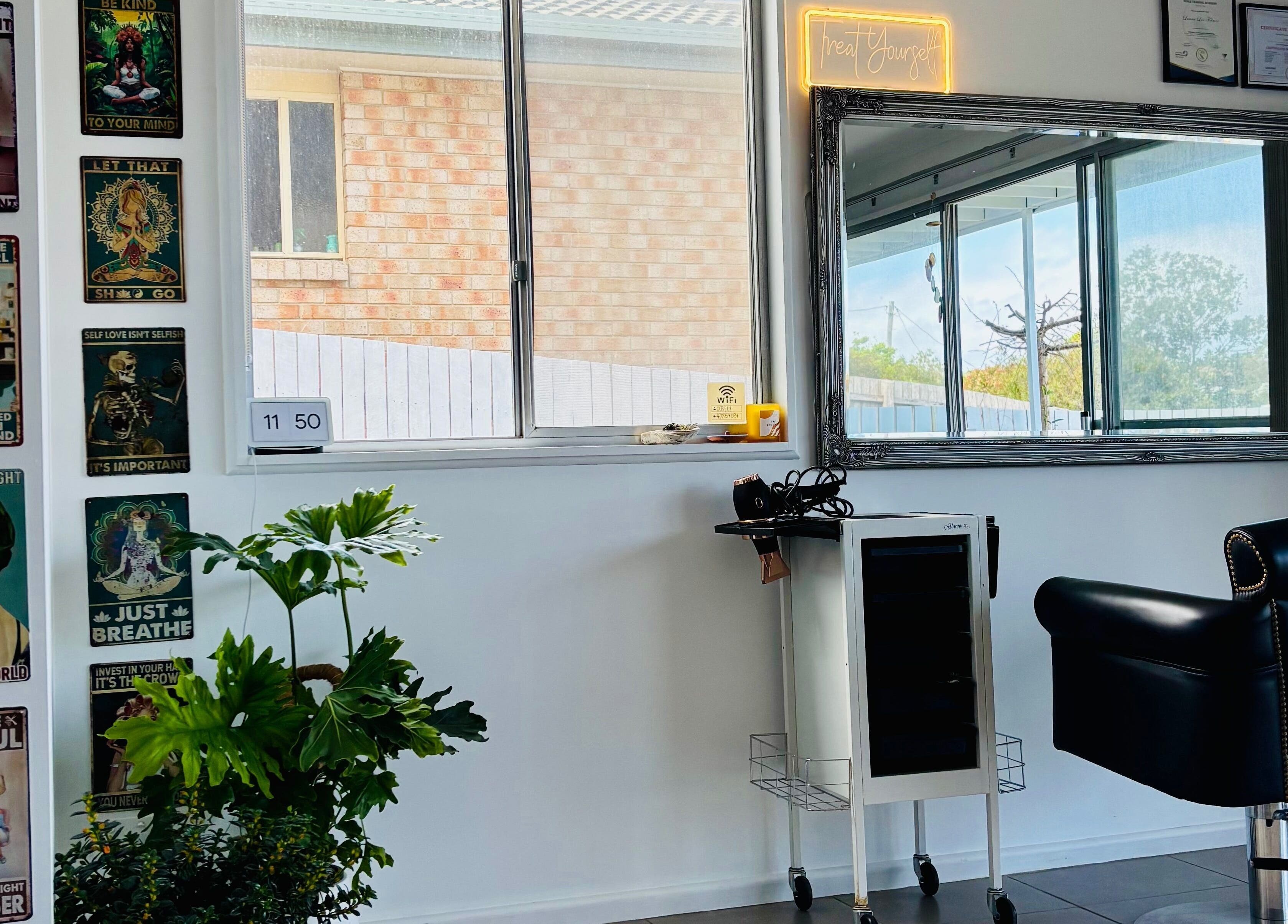 Chic salon interior with vintage posters and a styling chair at Tathra Hair Studio, Tathra, New South Wales, AU.