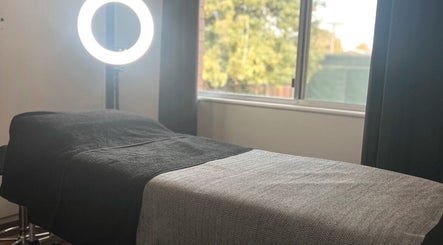 Beauty Bar 11 treatment room with a bed near a bright window in Flinders View, Queensland, AU.