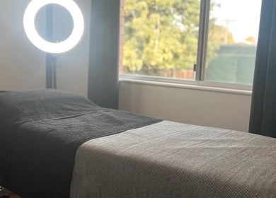 Serene beauty room at Beauty Bar 11, Flinders View, Queensland, AU with treatment bed and ring light.