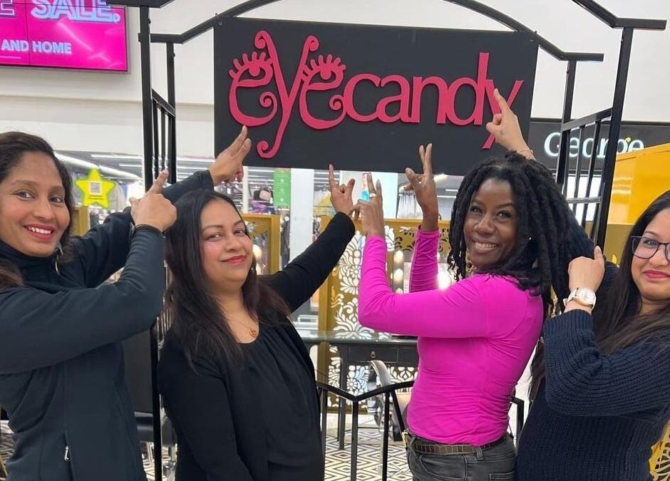 Team members pointing at Eyecandy Swindon sign in Swindon, England, GB.