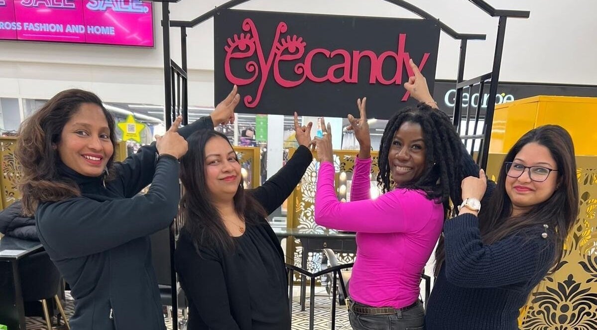 Team members pointing at Eyecandy Swindon sign in Swindon, England, GB.