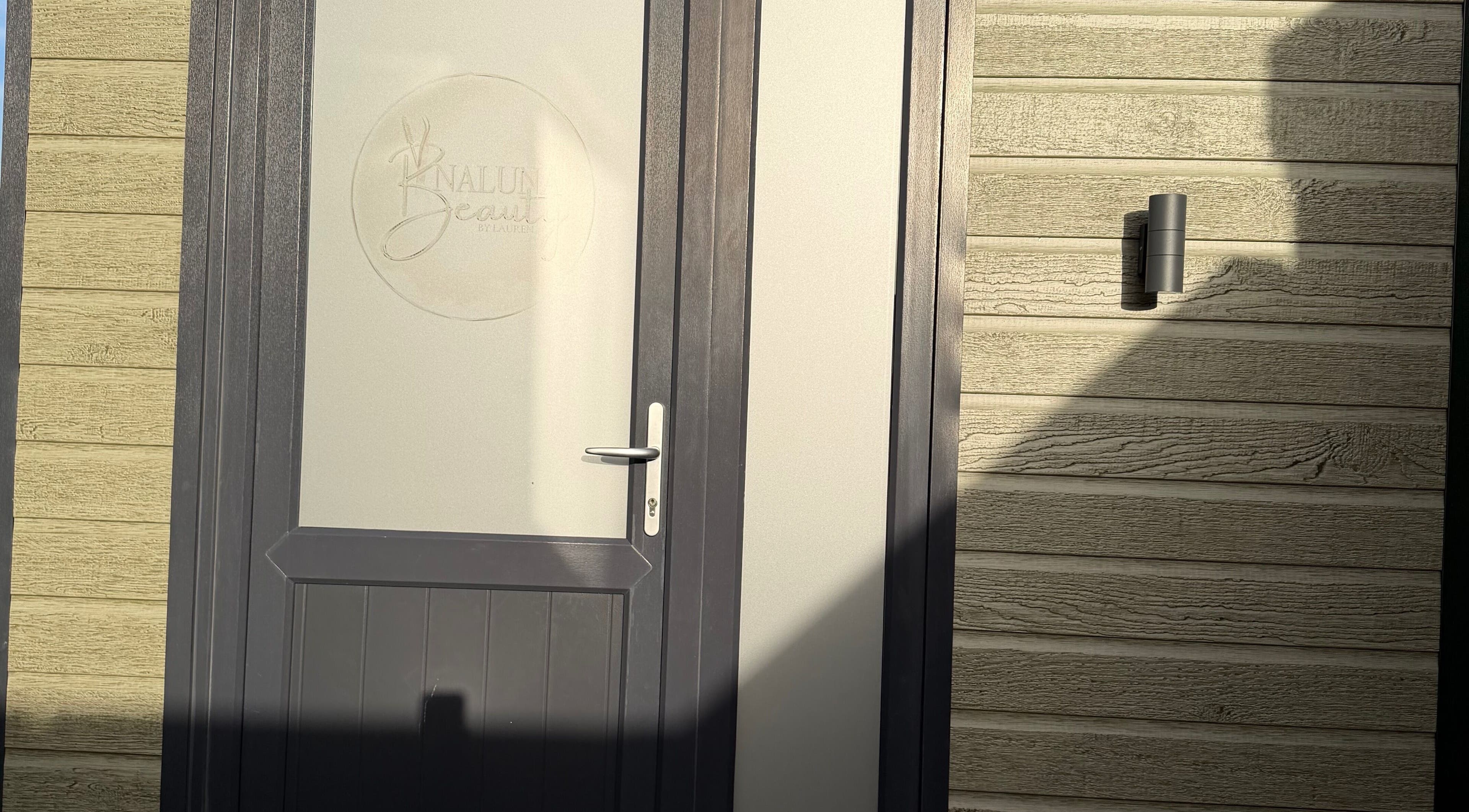 Front door of Naluna Beauty by Lauren in Garforth, England, GB with stylish wooden panel.