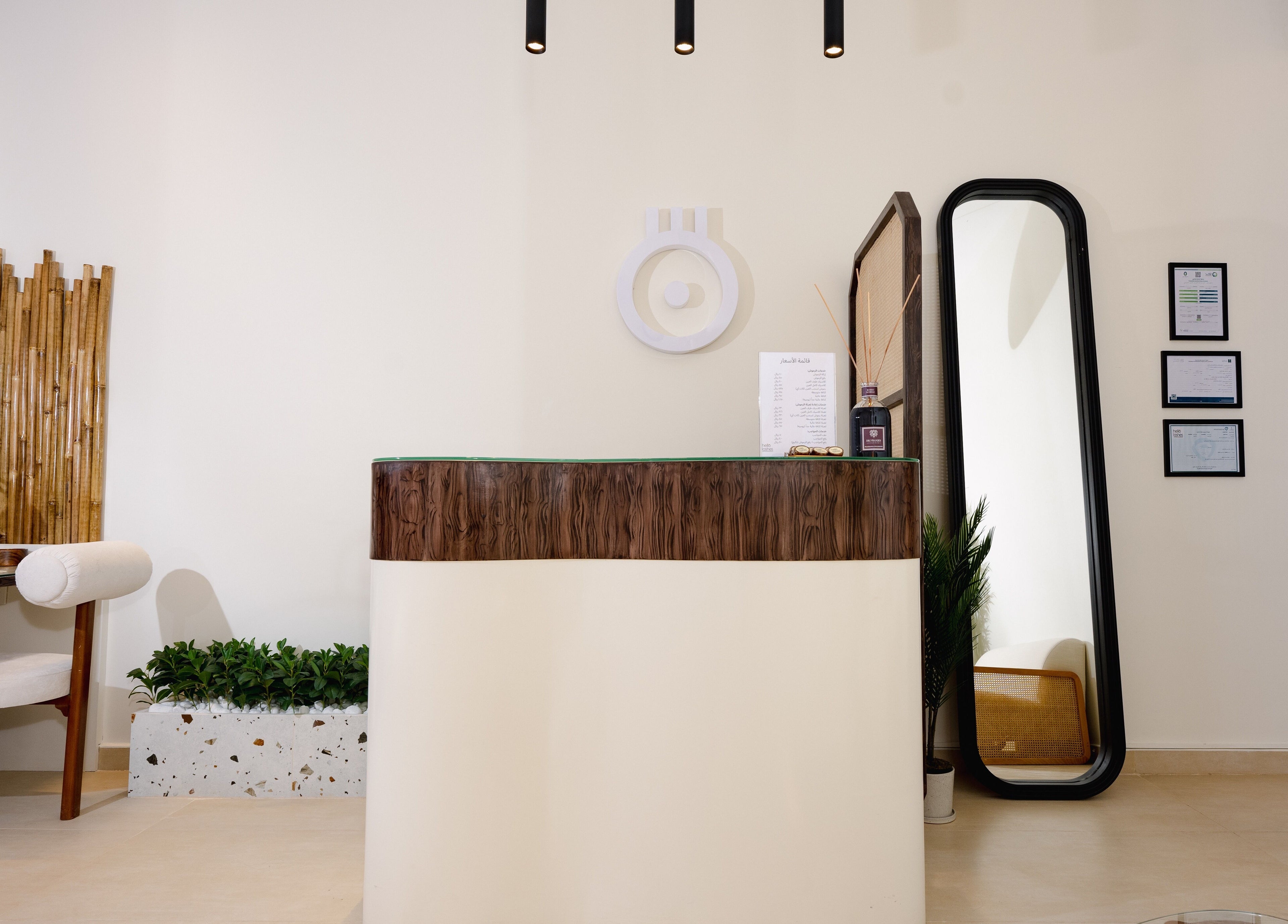 Elegant front desk at Hello Lashes, Riyadh, Riyadh Province, SA. Modern design with mirror and potted plant.