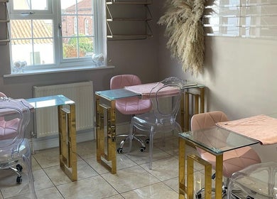 Elegant nail salon interior at Glamour, Bawtry, England, GB, featuring pink chairs and glass tables.