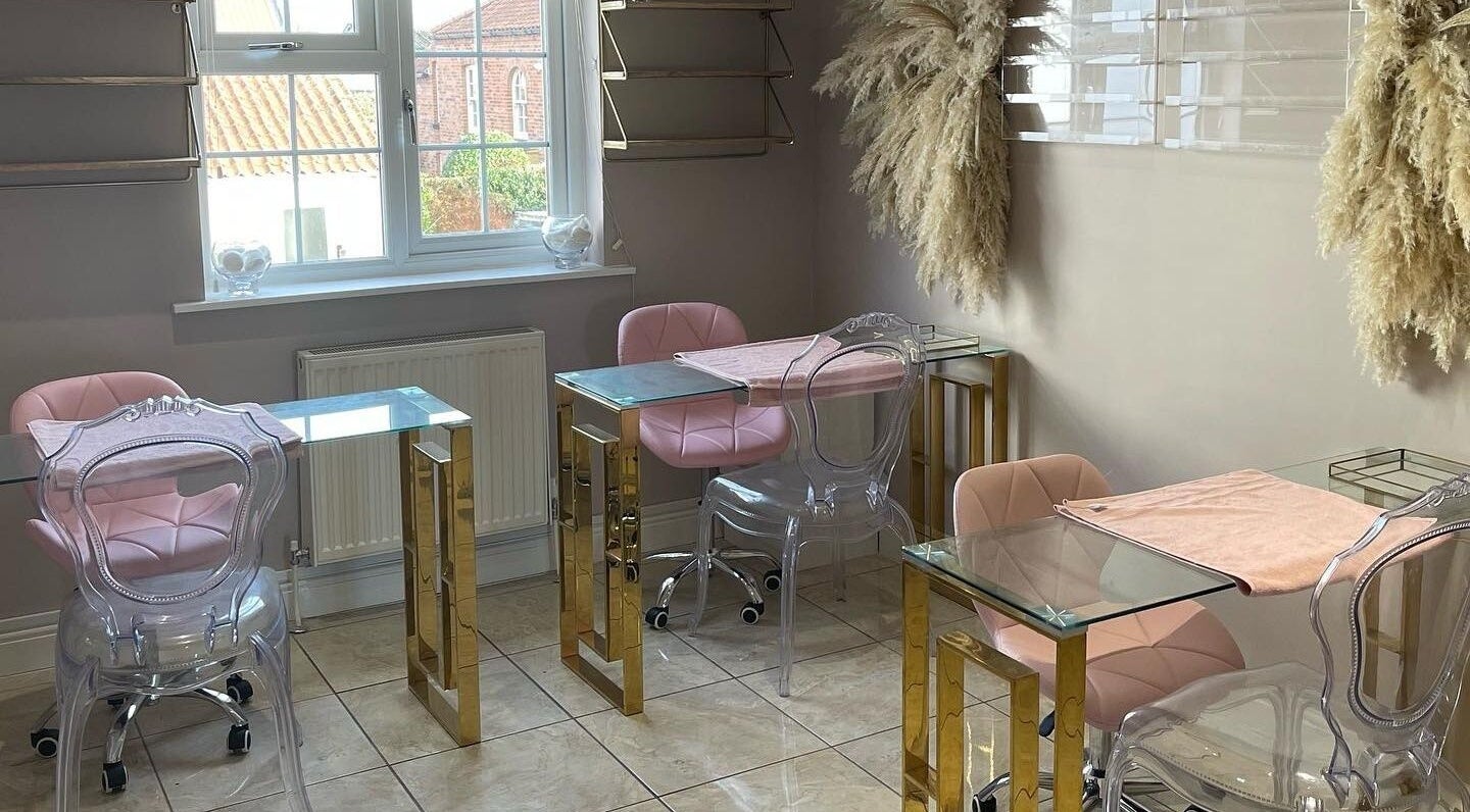 Elegant nail salon interior at Glamour, Bawtry, England, GB, featuring pink chairs and glass tables.