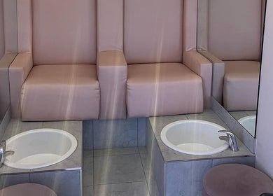 Stylish pedicure station at Glamour, Bawtry, England, GB featuring plush pink seating and modern basins.