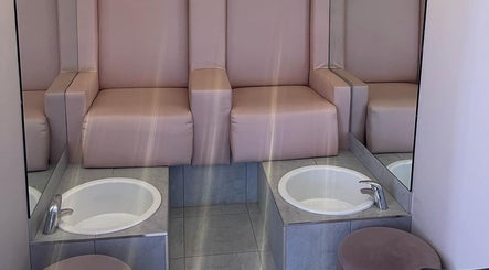 Stylish pedicure station at Glamour, Bawtry, England, GB featuring plush pink seating and modern basins.