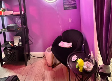 Cozy corner in Lemmey Esthetics, Addison, Texas featuring a plush chair and ambient lighting.