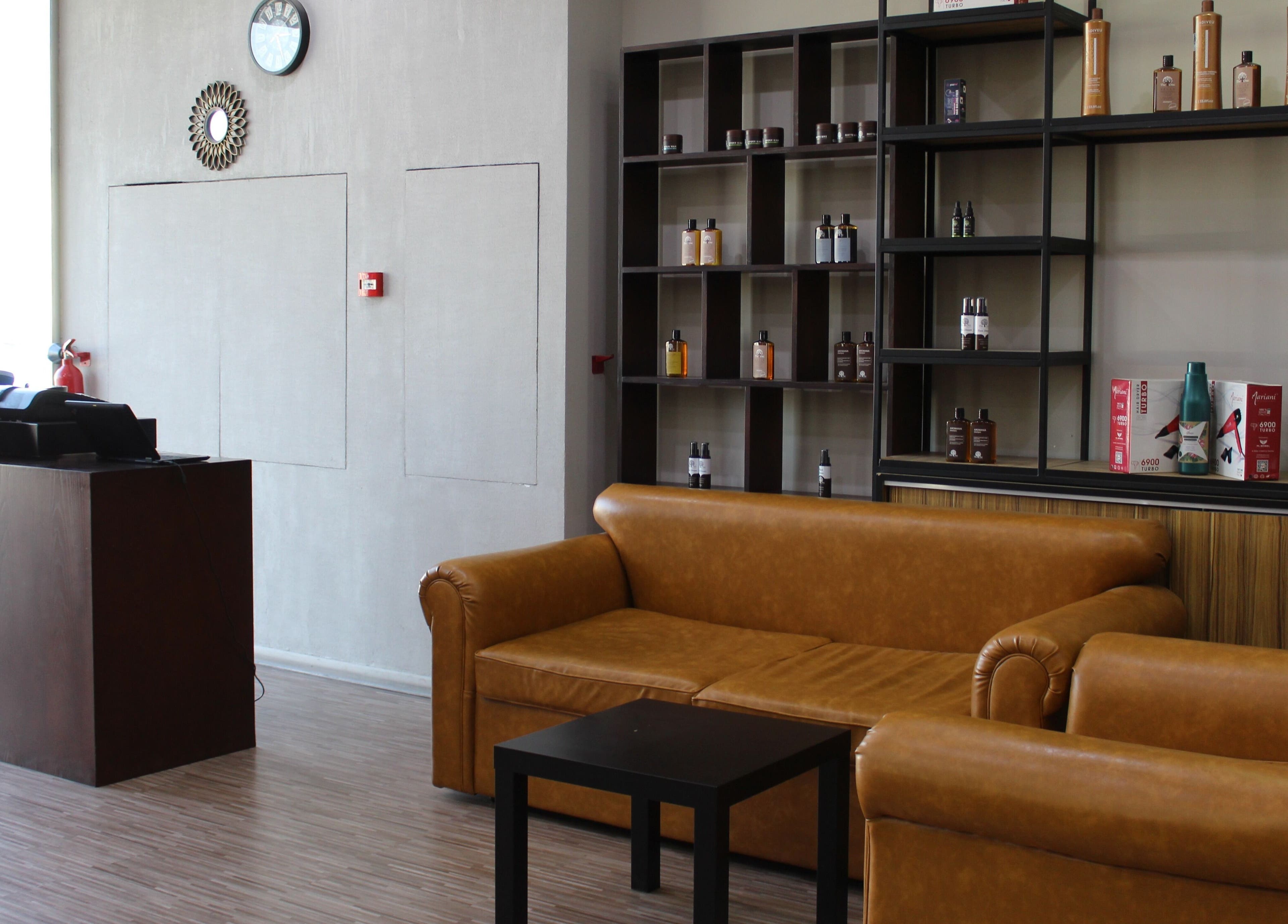 Relaxing lounge area at The One Gents Salon (Impz Branch), Dubai, Dubai, AE, featuring brown leather sofas.