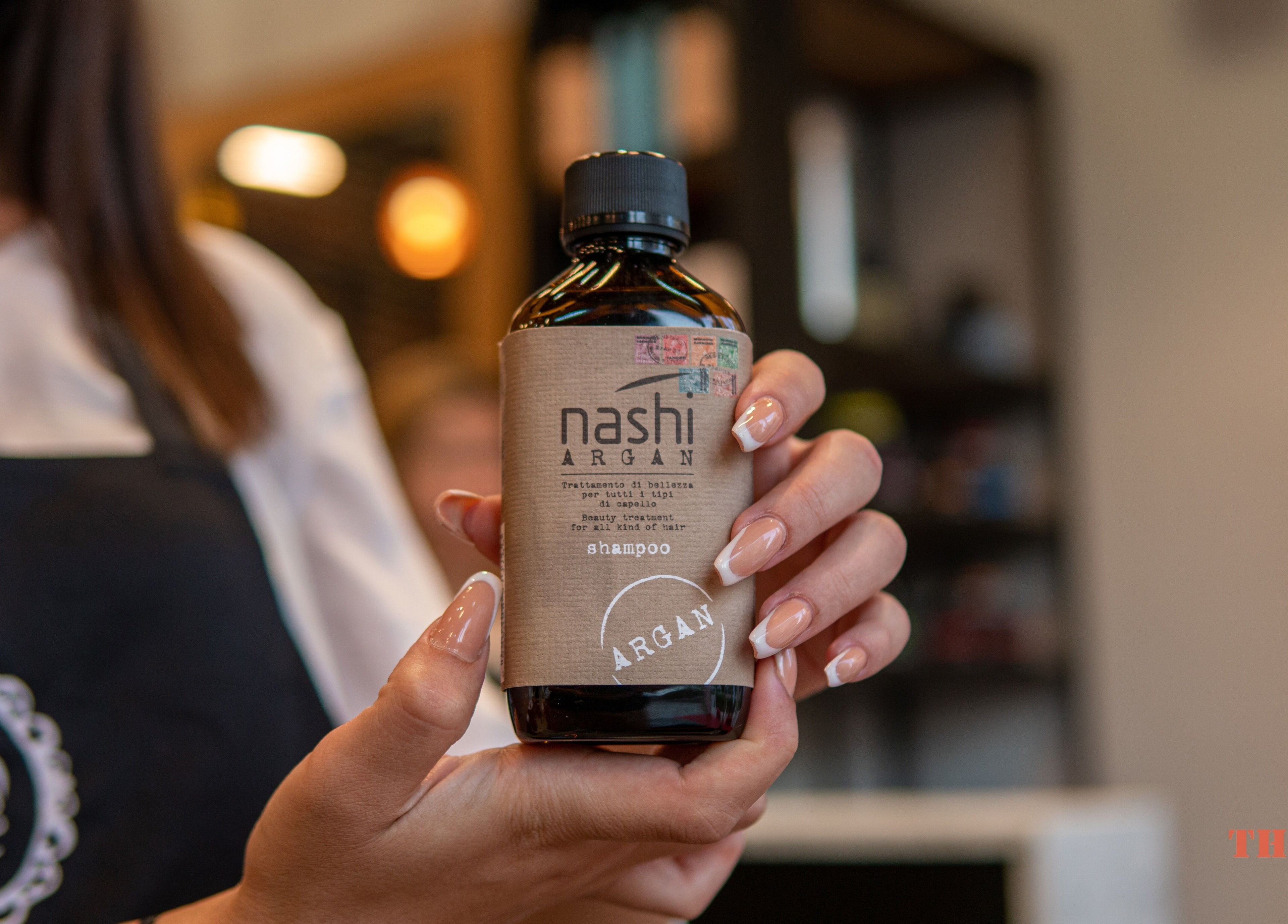 Woman presenting Nashi Argan shampoo at The One Gents Salon (Tecom Branch), Dubai, Dubai, AE.