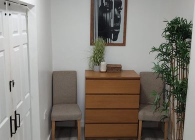 Relaxed waiting area at Wake Up With Brows UK, London, GB. Features cozy chairs and decorative plants.
