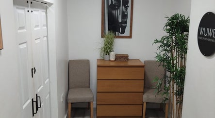 Relaxed waiting area at Wake Up With Brows UK, London, GB. Features cozy chairs and decorative plants.