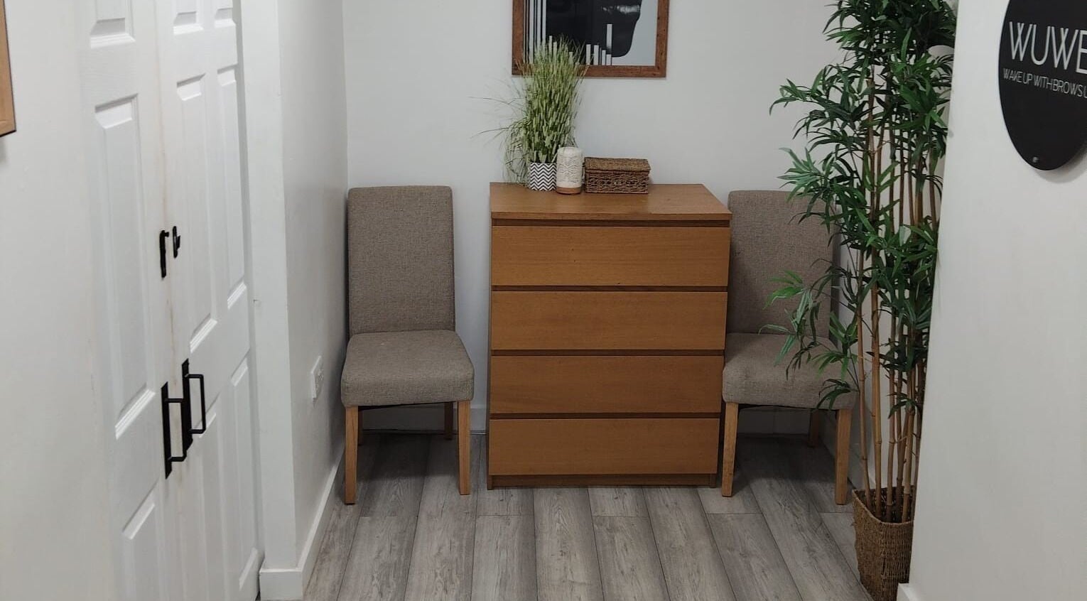 Cozy waiting area at Wake Up With Brows UK, featuring chairs and greenery in London, GB.