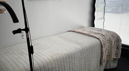 Relaxing treatment bed at Extensions By JayD in Oakville, Ontario, CA, with soft lighting for comfort.