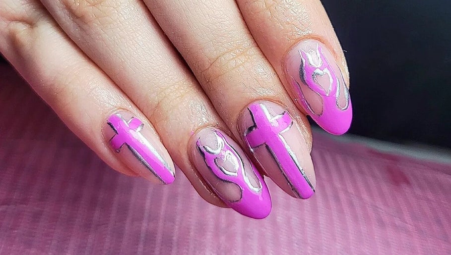 Creative pink nail art at Clouds Beauty Studio, London, England, GB showcasing intricate cross patterns.