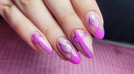Creative pink nail art at Clouds Beauty Studio, London, England, GB showcasing intricate cross patterns.