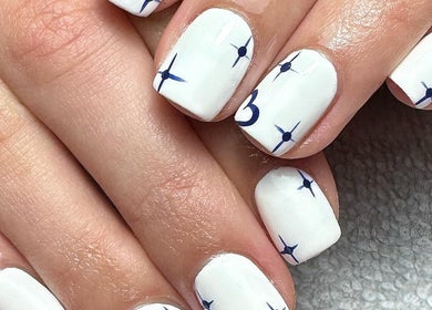 Elegant white nails with blue star design at Clouds Beauty Studio, London, England, GB.