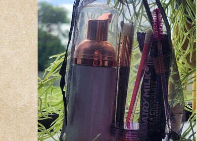 Beauty essentials in a bag at KALAYNA LASHES, Tauranga, BOP, NZ, set against a leafy backdrop.
