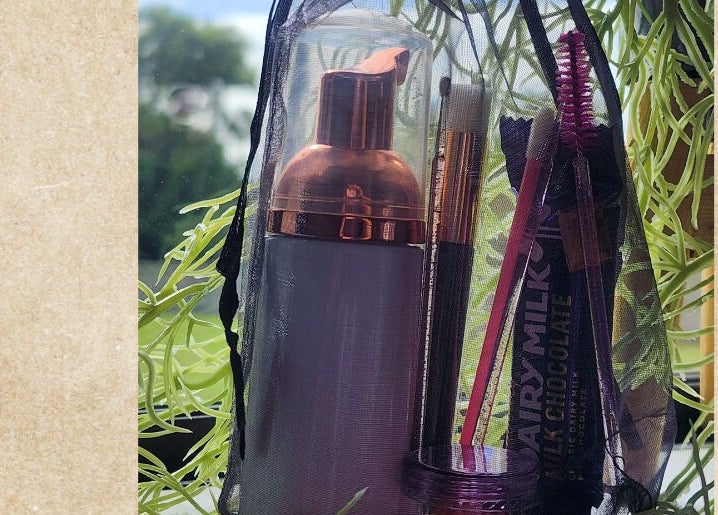 Beauty essentials in a bag at KALAYNA LASHES, Tauranga, BOP, NZ, set against a leafy backdrop.