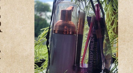 Beauty essentials in a bag at KALAYNA LASHES, Tauranga, BOP, NZ, set against a leafy backdrop.