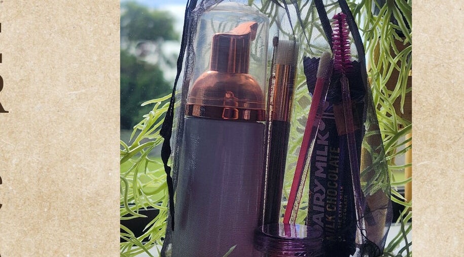 Beauty essentials in a bag at KALAYNA LASHES, Tauranga, BOP, NZ, set against a leafy backdrop.
