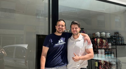 Dos personas sonrientes frente a CONSULTA DE NUTRICIÓN en Martos, Andalucía, ES.
