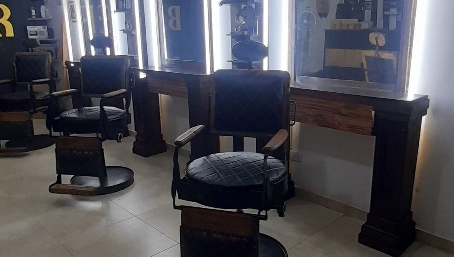 Interior de Sir Barber en Moron, Provincia de Buenos Aires, AR, con sillas y espejos iluminados.