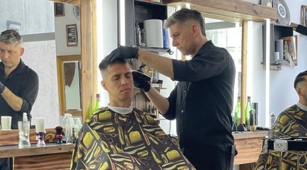 Barbero en SIR BARBER, Moron, Provincia de Buenos Aires, AR, realizando un corte de cabello moderno.