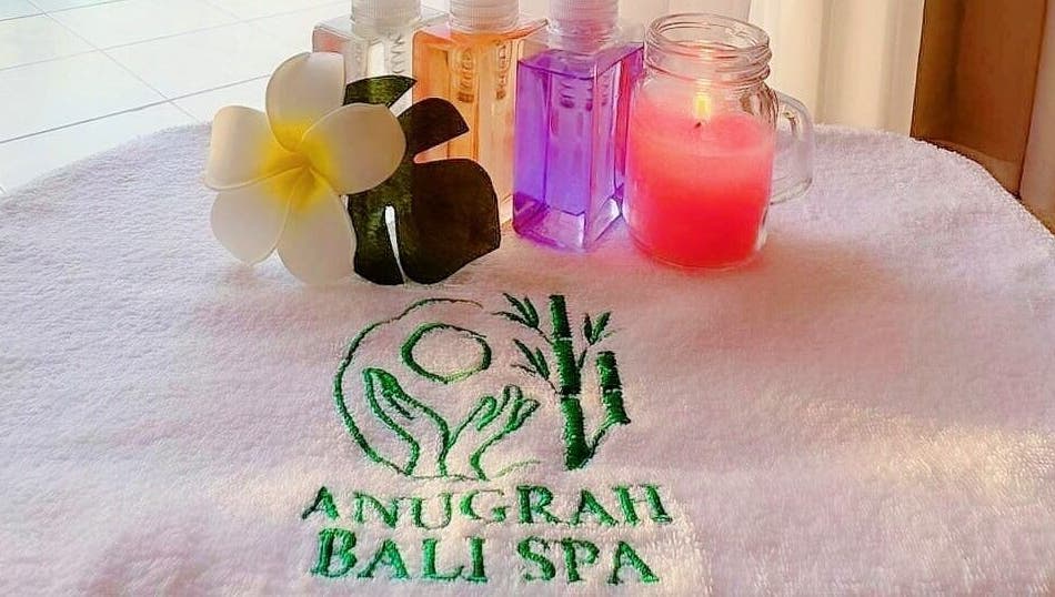 Relaxing spa essentials at Anugrah Bali Spa Home, Office and Events in Dubai, AE, featuring oils and a candle.