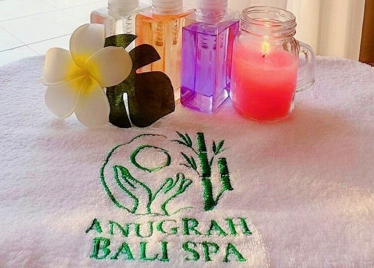 Relaxing spa essentials at Anugrah Bali Spa Home, Office and Events in Dubai, AE, featuring oils and a candle.