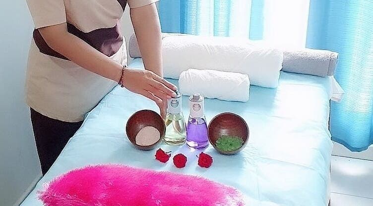 Massage room setup at Anugrah Bali Spa Home, Office and Events, Dubai, AE with oils and towels on a bed.