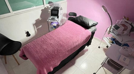 Sala de tratamiento de Chula BW en Naucalpan De Juárez, Estado De México, con decoración rosa y cama de masaje.