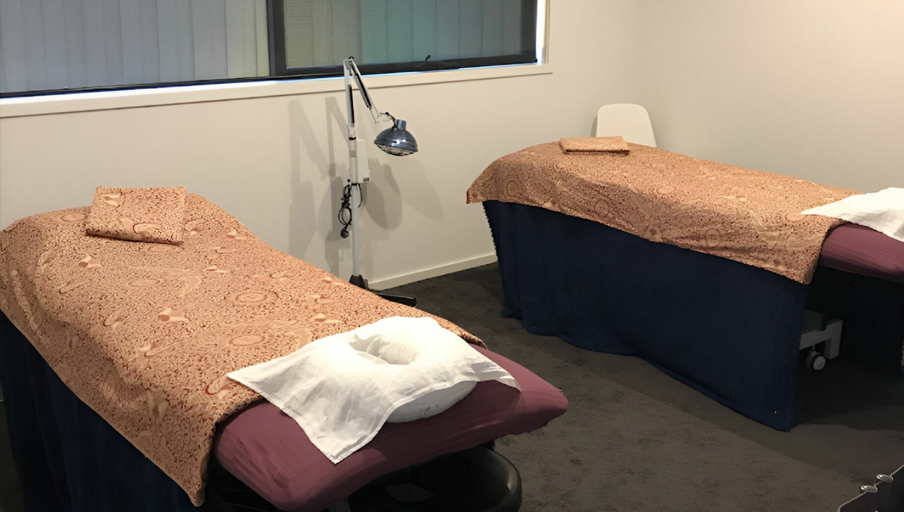 Cozy massage room at Yuan Muscle Therapy, Melbourne, Victoria, AU, featuring two massage tables with patterned covers.