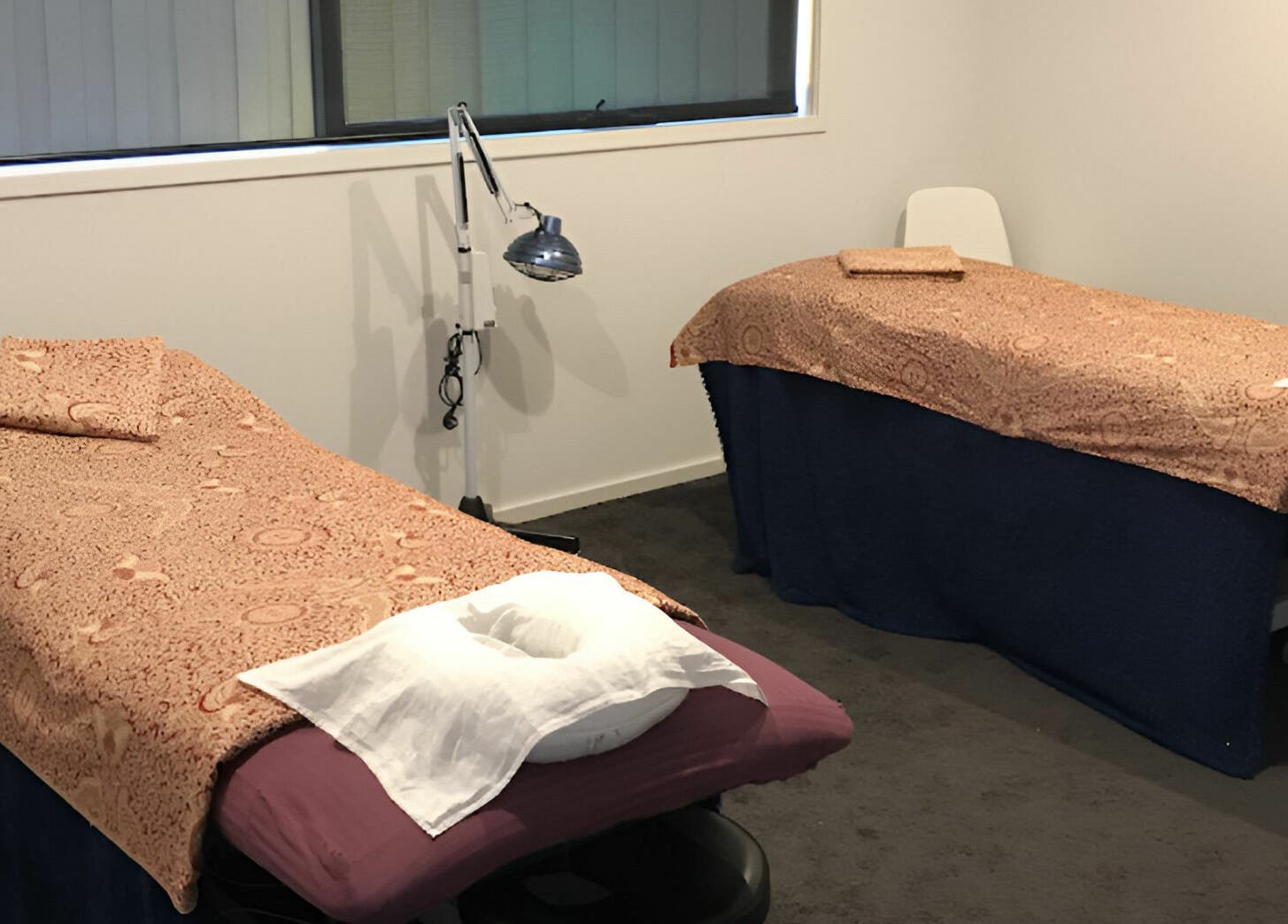 Cozy massage room at Yuan Muscle Therapy, Melbourne, Victoria, AU, featuring two massage tables with patterned covers.