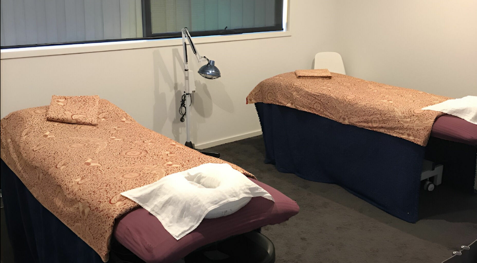 Cozy massage room at Yuan Muscle Therapy, Melbourne, Victoria, AU, featuring two massage tables with patterned covers.
