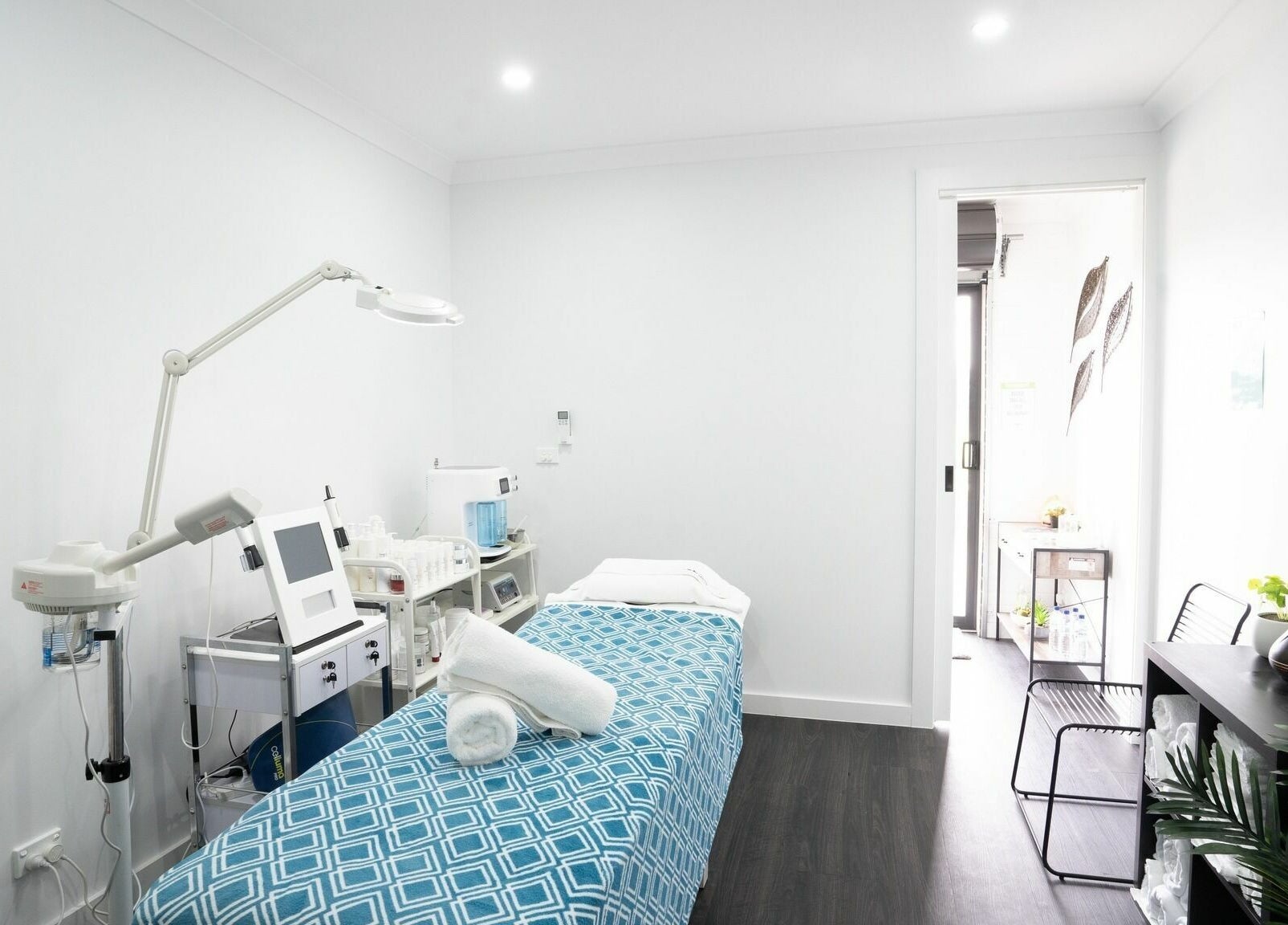Calm treatment room at I Glow Skin Spa, Burnside, Victoria, AU, featuring a massage table and modern equipment.