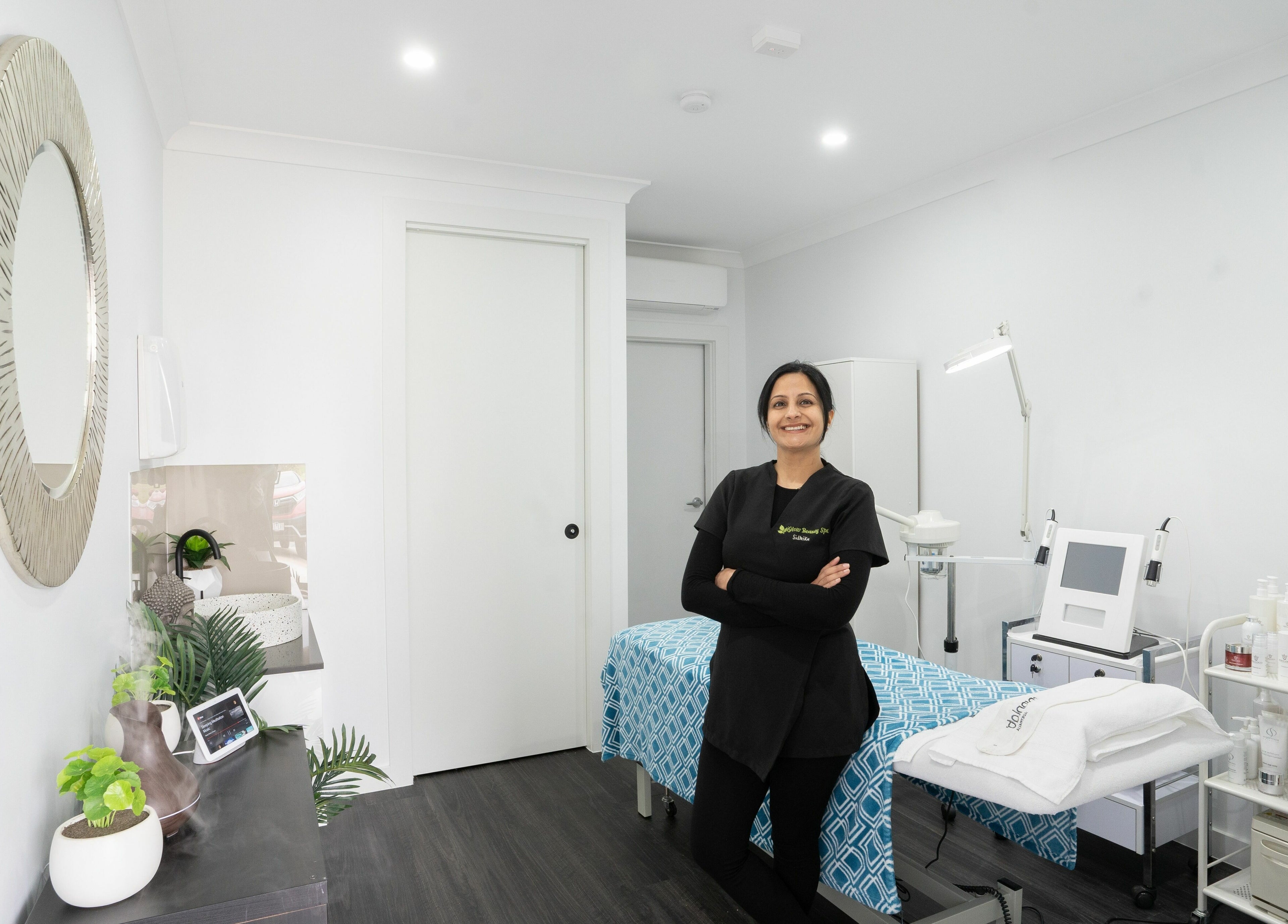 Relaxing treatment room at I Glow Skin Spa in Burnside, Victoria, AU with a smiling staff member.