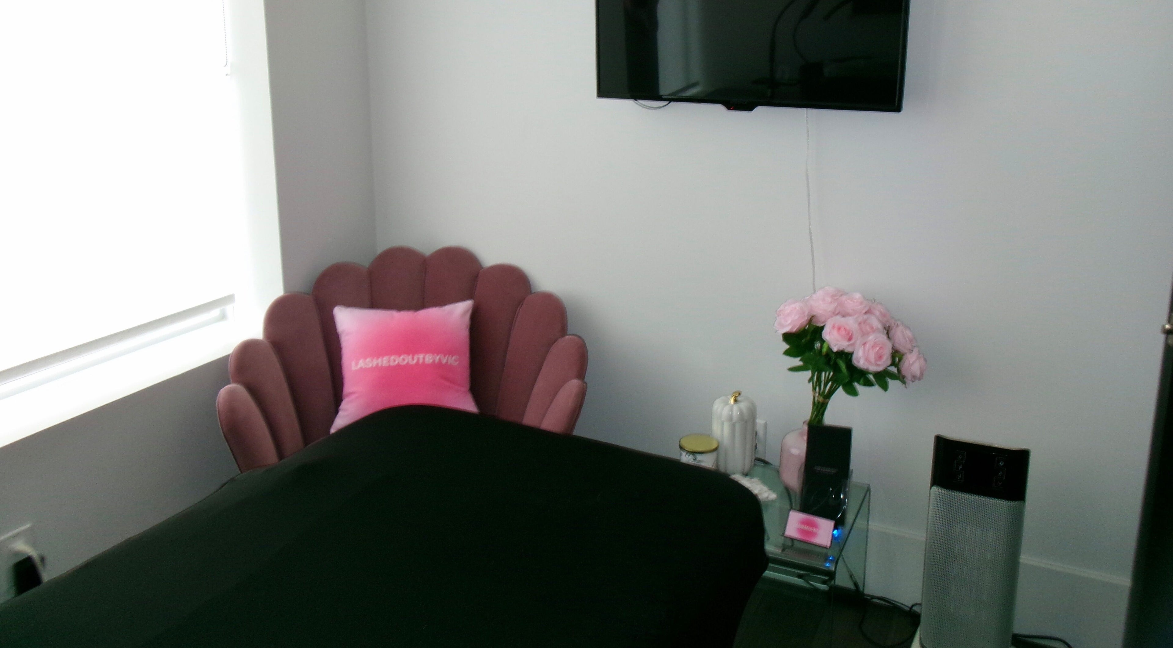 Elegant, cozy corner at Victoria | Lashed Out by Vic in Vaughan, Ontario, CA featuring a plush pink chair.
