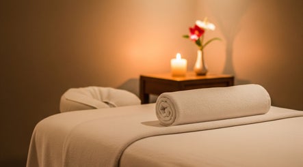 Sala massaggio rilassante presso NEW MOON, Lugano, Ticino, CH con candela e asciugamano bianco.