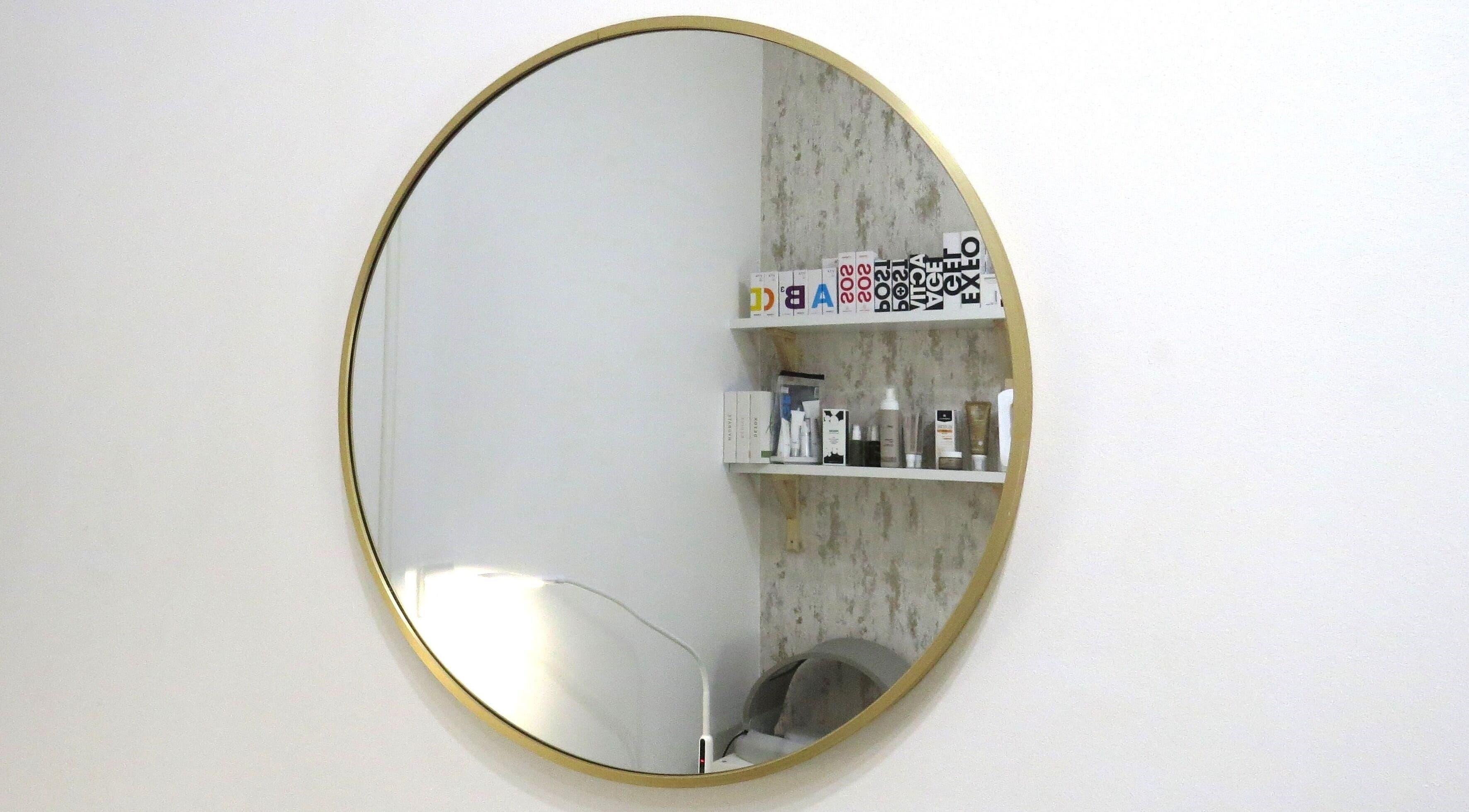 Round mirror reflecting shelves at Tide and Drift - Skin Therapy, Sheringham, England, GB.
