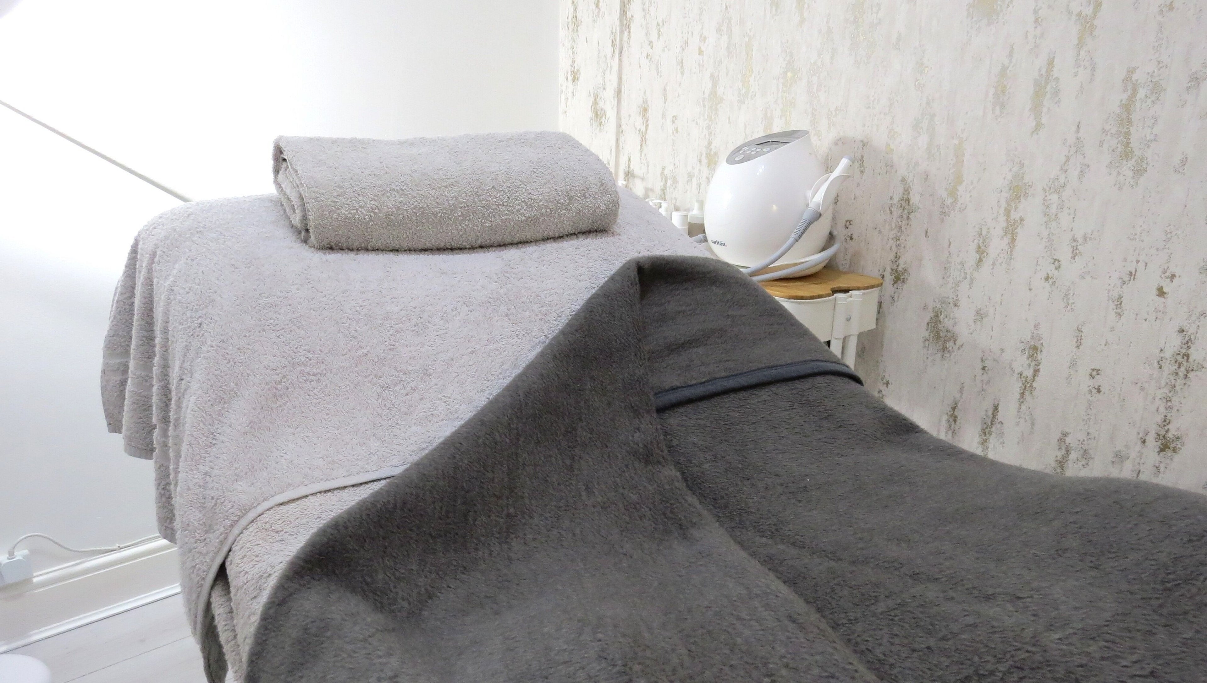 Cozy treatment bed at Tide and Drift - Skin Therapy, Sheringham, England, GB, exuding relaxation and comfort.