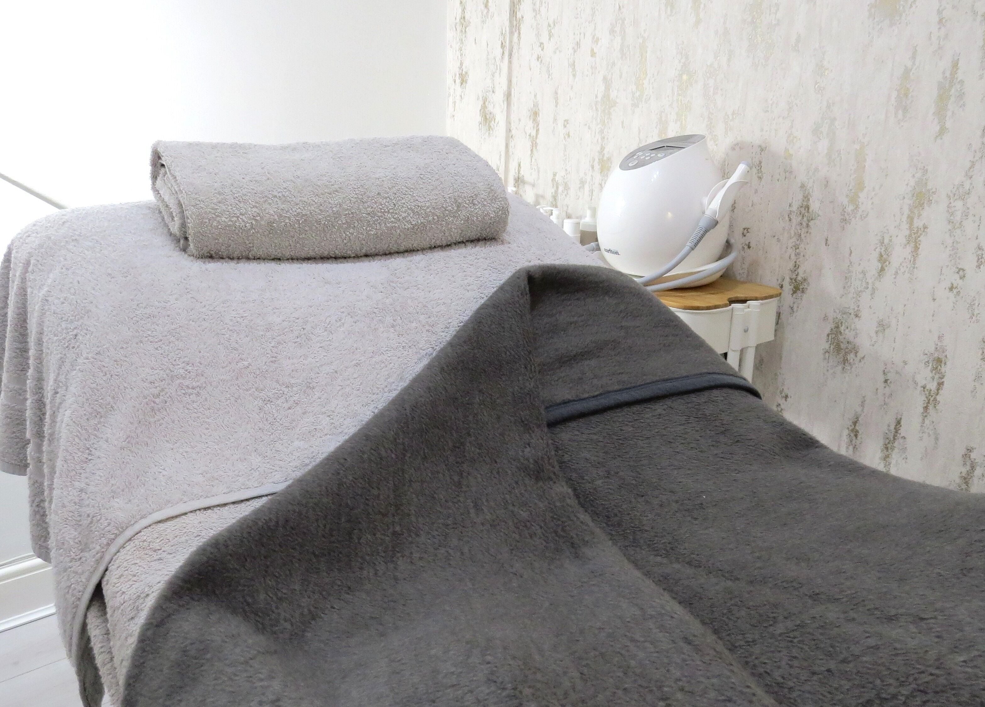 Cozy treatment bed at Tide and Drift - Skin Therapy, Sheringham, England, GB, exuding relaxation and comfort.