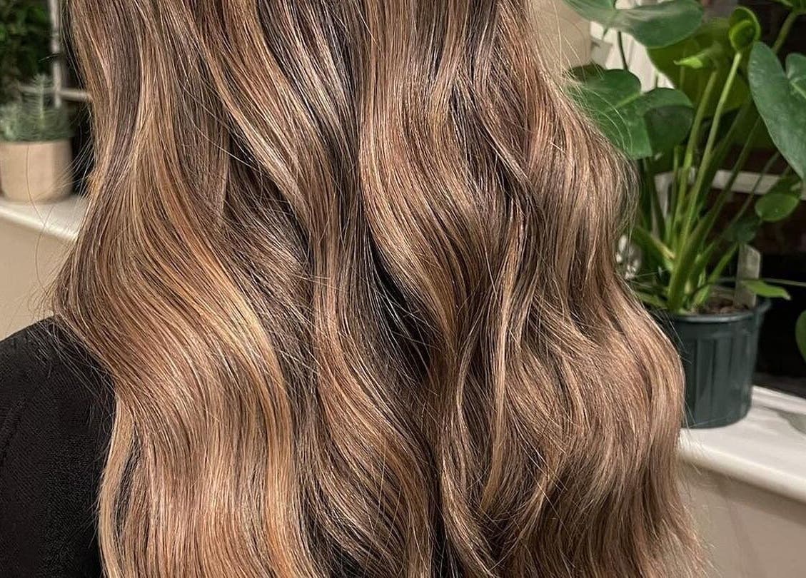Beautifully styled wavy hair at The Green House Salon, Birmingham, England, GB with indoor plants.