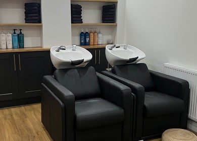 Luxury wash stations at The Hair Edit, Manchester, England, GB, featuring sleek black chairs and elegant cabinetry.