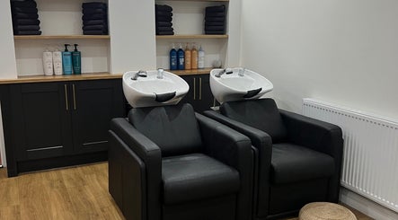 Luxury wash stations at The Hair Edit, Manchester, England, GB, featuring sleek black chairs and elegant cabinetry.