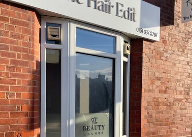 Entrance of The Hair Edit beauty lounge in Manchester, England, GB with brick walls and signage.