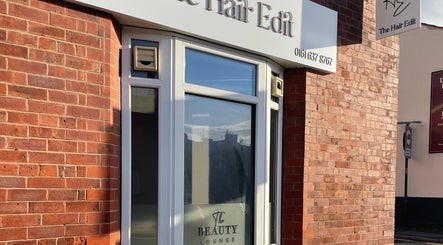 Entrance of The Hair Edit beauty lounge in Manchester, England, GB with brick walls and signage.
