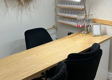 Manicure table setup at The Hair Edit, Manchester, England, GB, featuring nail polish racks and comfortable seating.