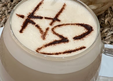 Coffee with unique latte art at The Hair Edit in Manchester, England, GB on a woven mat.